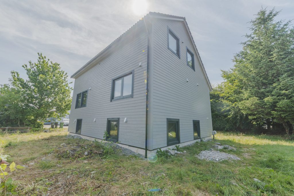 Gavlvegg på nybygd bolig med gråkledd fasade